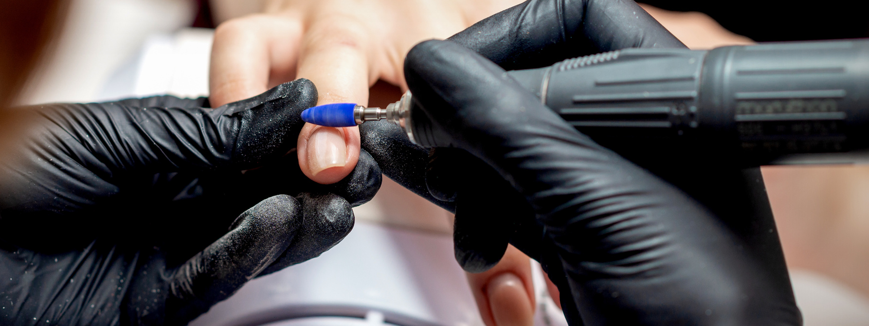 Manicurist Applying Electric Nail File Drill