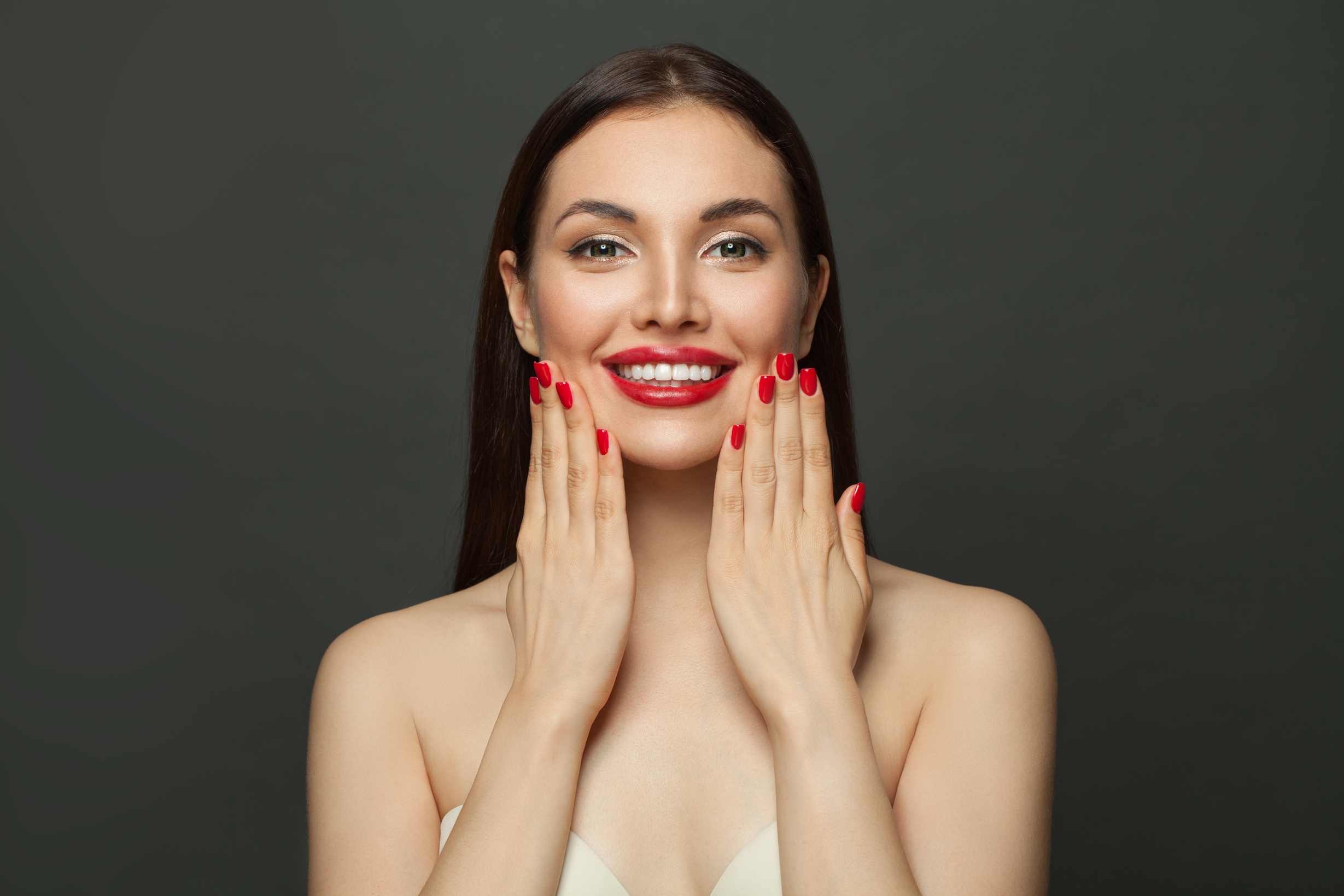 Healthy model woman showing red manicured nails